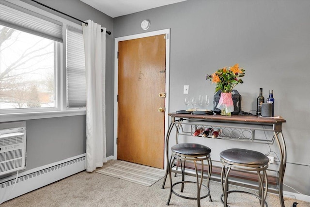 interior space with a bar, a baseboard radiator, baseboards, and light colored carpet