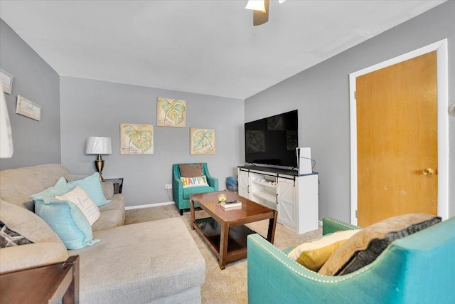 living room with baseboards, a ceiling fan, and light colored carpet