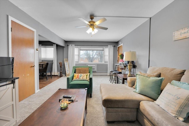 carpeted living area featuring ceiling fan, baseboard heating, and a wall mounted air conditioner