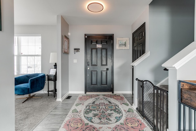 entrance foyer with visible vents, baseboards, and wood finished floors