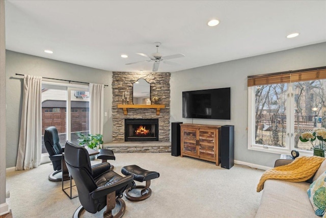 carpeted living area featuring recessed lighting, baseboards, a ceiling fan, and a stone fireplace