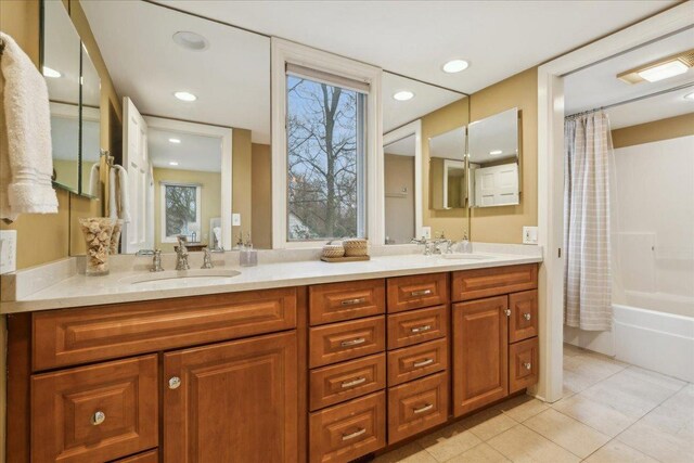 bathroom with double vanity, a sink, shower / bathtub combination with curtain, and tile patterned floors