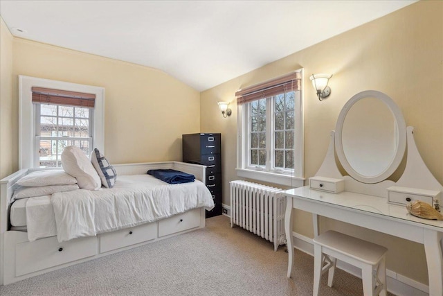 bedroom featuring radiator heating unit, vaulted ceiling, and light colored carpet