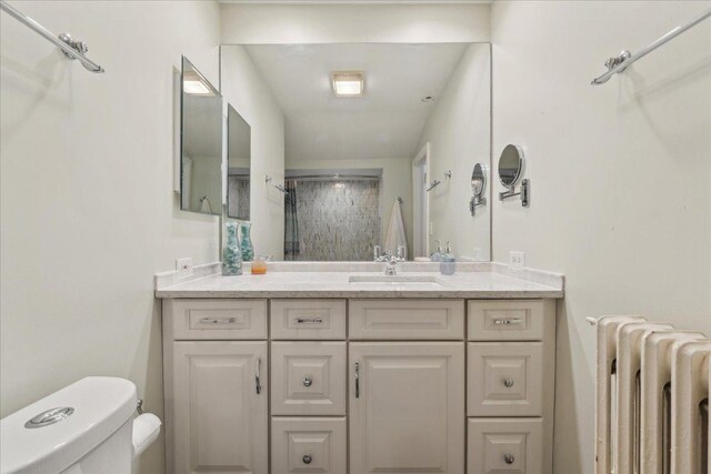 bathroom featuring radiator, toilet, and vanity