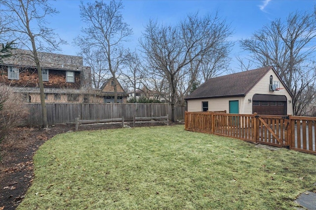 view of yard featuring a fenced backyard, an outdoor structure, and a detached garage