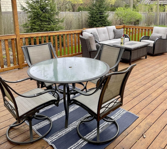 wooden deck featuring outdoor dining area, fence, and outdoor lounge area