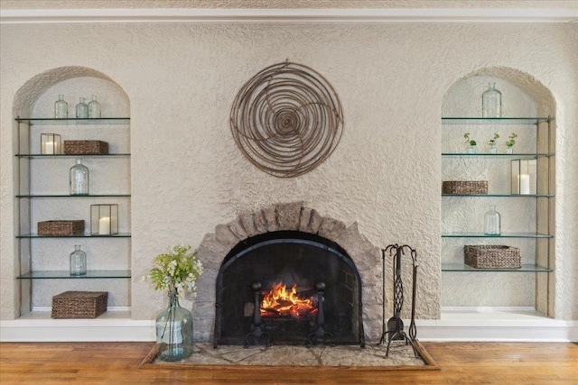 room details with a fireplace with flush hearth, wood finished floors, and built in features