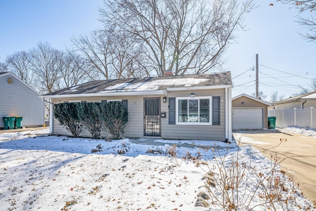 view of front facade featuring a garage, driveway, a chimney, and an outdoor structure