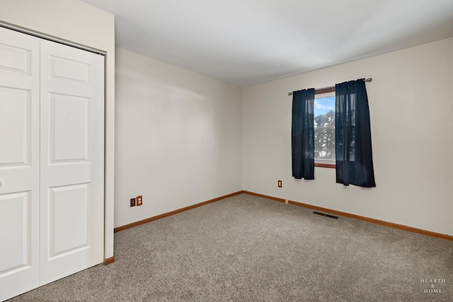 unfurnished bedroom featuring carpet, a closet, visible vents, and baseboards