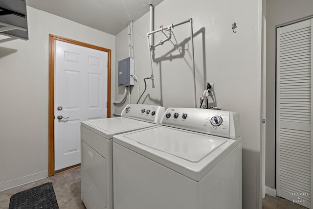 laundry area with laundry area, electric panel, baseboards, and separate washer and dryer