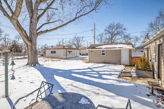 snowy yard with fence and an outdoor structure