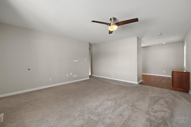 empty room featuring ceiling fan, dark colored carpet, and baseboards