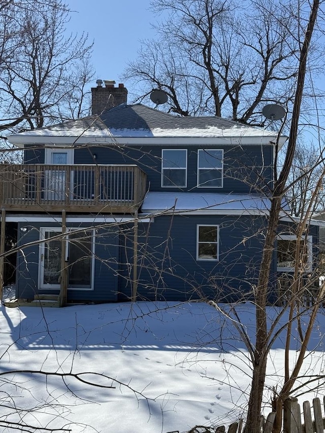 snow covered property with a chimney