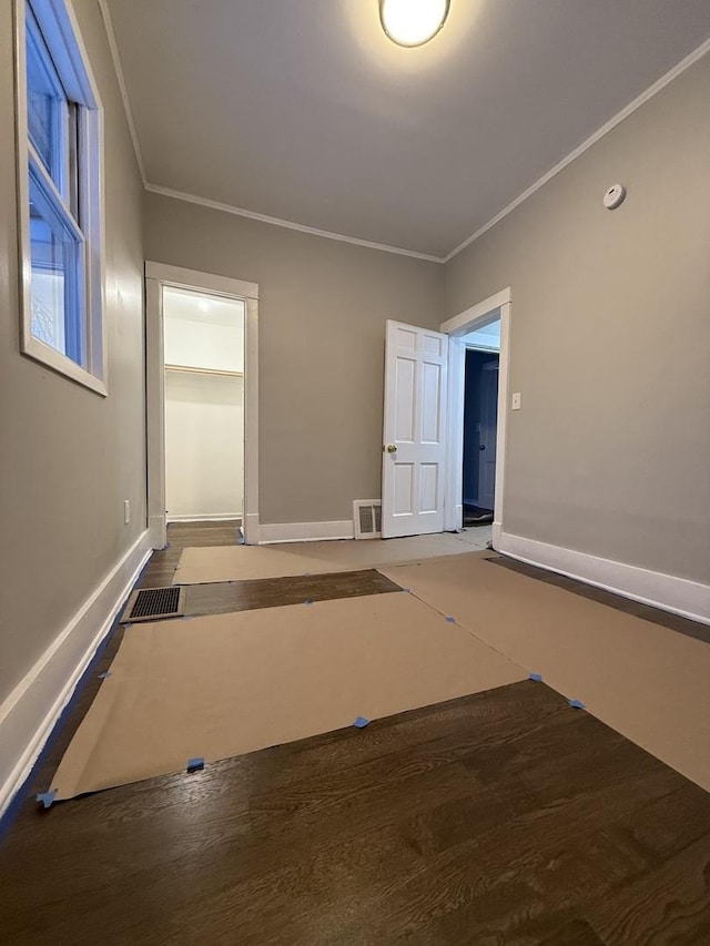 spare room featuring ornamental molding, visible vents, and baseboards