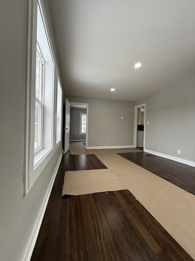 spare room featuring dark wood-style floors, recessed lighting, and baseboards