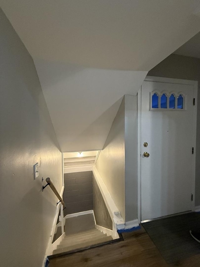 stairs featuring vaulted ceiling and wood finished floors