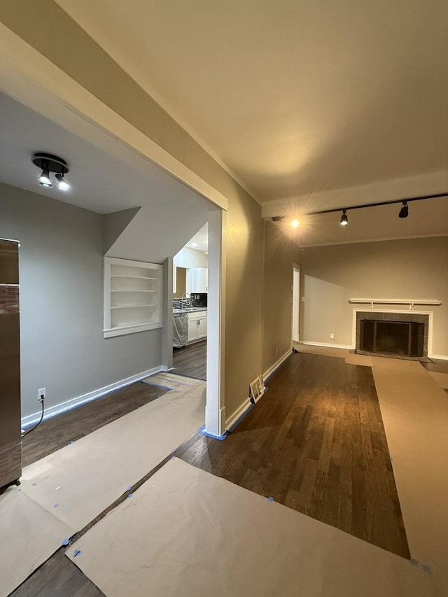 interior space featuring built in shelves, wood finished floors, visible vents, and baseboards