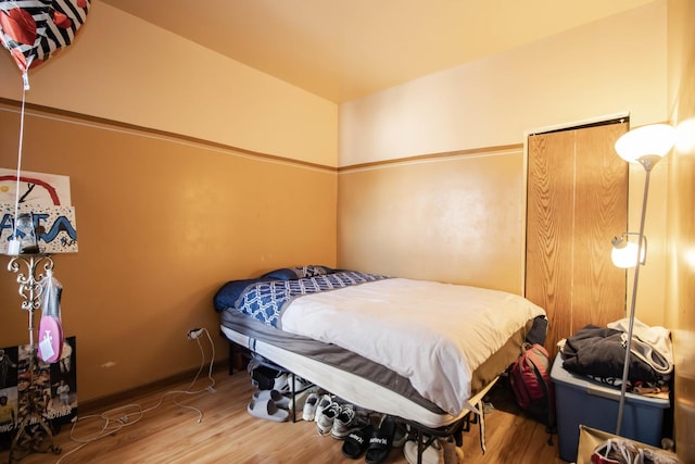 bedroom with baseboards and wood finished floors