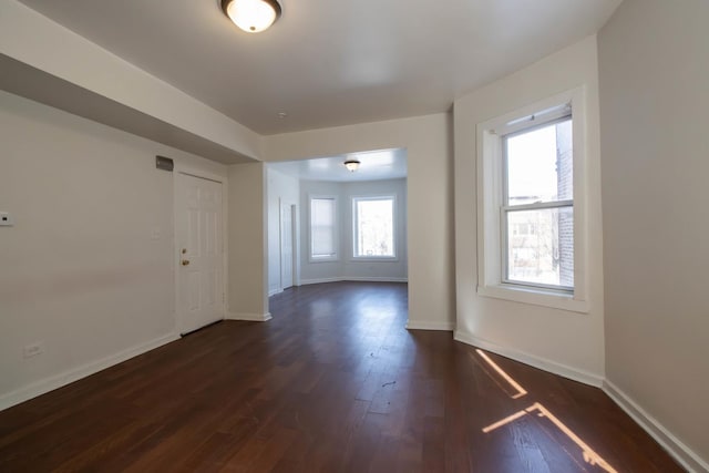 unfurnished room with dark wood-style floors and baseboards