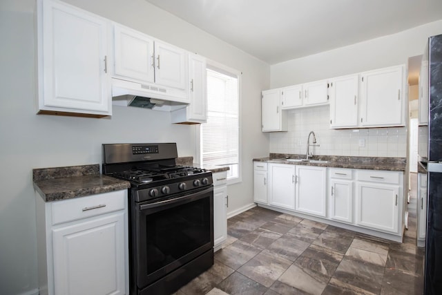 kitchen with tasteful backsplash, dark countertops, gas stove, white cabinets, and under cabinet range hood