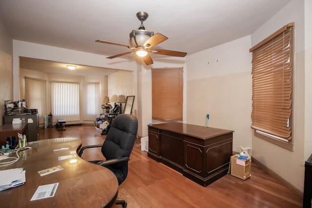 office area featuring light wood-style floors, ceiling fan, and baseboards