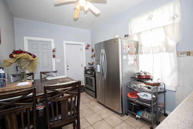 kitchen featuring light tile patterned floors, stainless steel appliances, and a ceiling fan