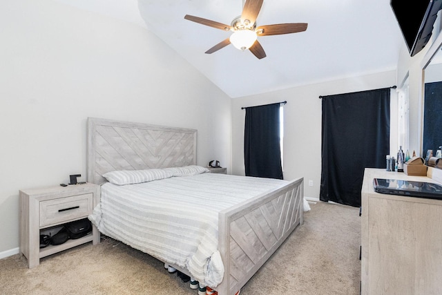 bedroom with light colored carpet, vaulted ceiling, baseboards, and ceiling fan