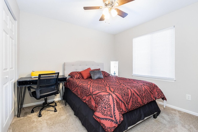 bedroom with light carpet, a ceiling fan, baseboards, and a closet