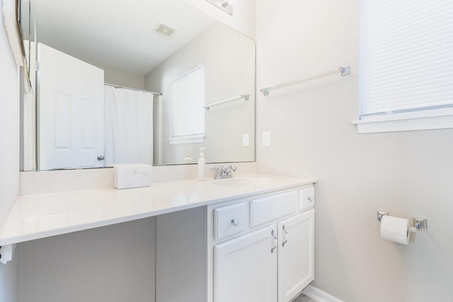 bathroom featuring visible vents, vanity, and baseboards