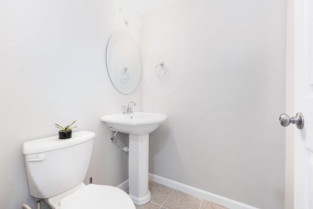 bathroom with baseboards, toilet, and tile patterned floors