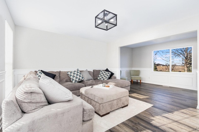 living room featuring a wainscoted wall and wood finished floors