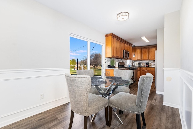 dining room with wainscoting and dark wood finished floors