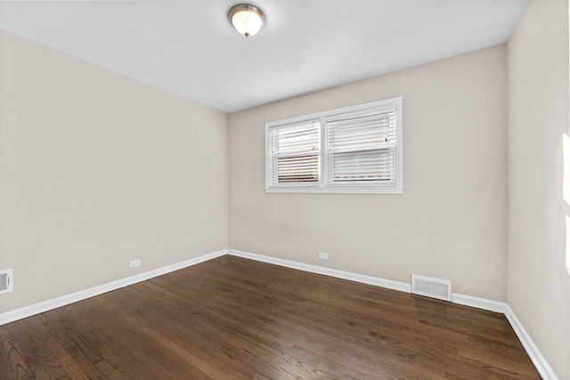 unfurnished room with dark wood-style floors, baseboards, and visible vents