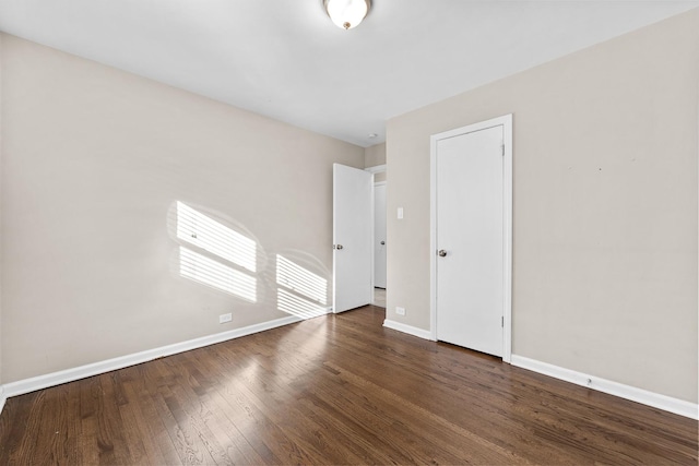 unfurnished room featuring dark wood-style floors and baseboards