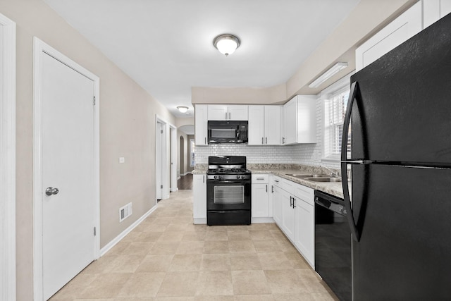 kitchen featuring visible vents, decorative backsplash, white cabinetry, a sink, and black appliances