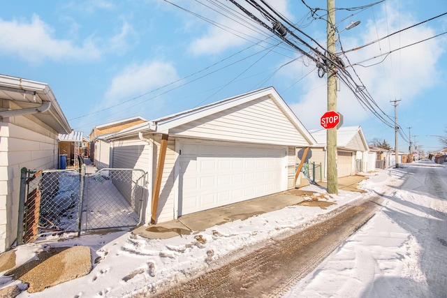 view of home's exterior with an outbuilding, a detached garage, and fence