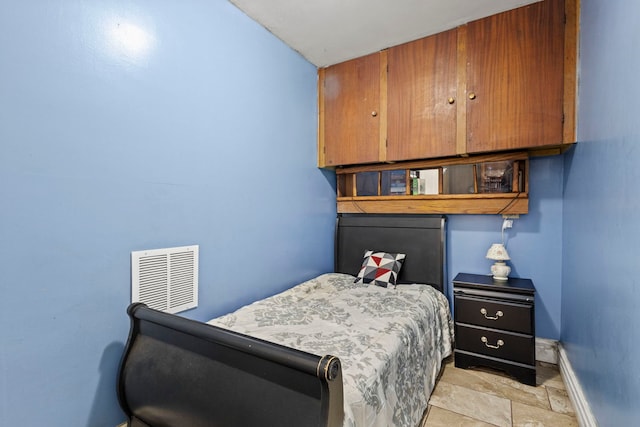 bedroom featuring baseboards, visible vents, and stone finish flooring