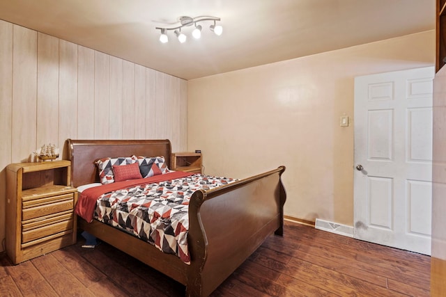 bedroom with dark wood-style floors, visible vents, and baseboards