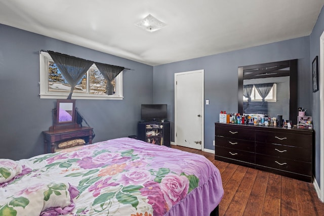 bedroom with dark wood-style floors and baseboards