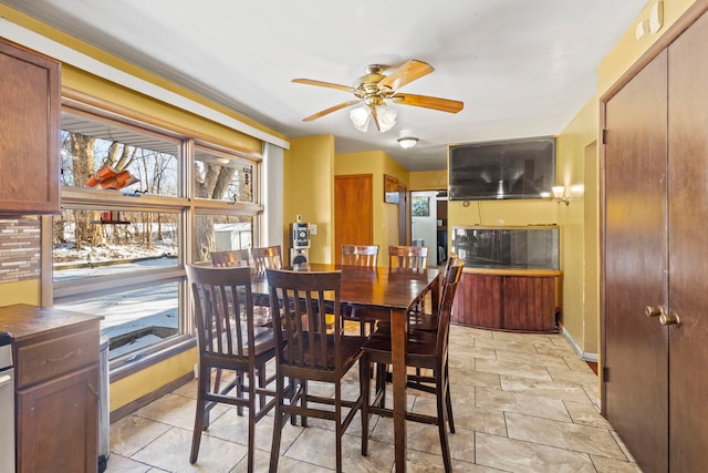 dining room with a ceiling fan and baseboards