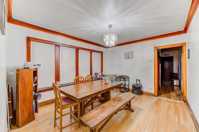 dining area featuring ornamental molding, light wood finished floors, a chandelier, and baseboards