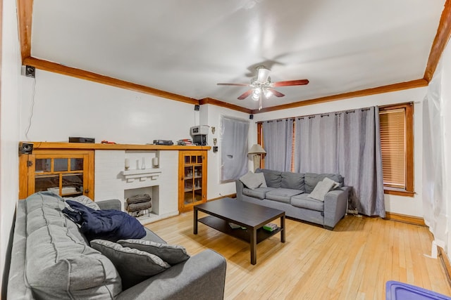 living area featuring light wood-type flooring, ceiling fan, baseboards, and crown molding