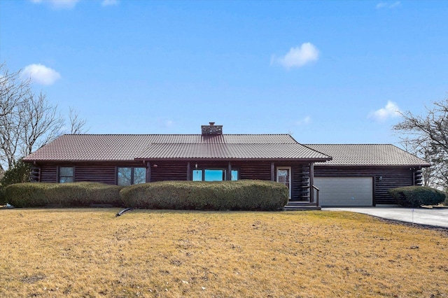 single story home with an attached garage, concrete driveway, a tiled roof, a front lawn, and a chimney