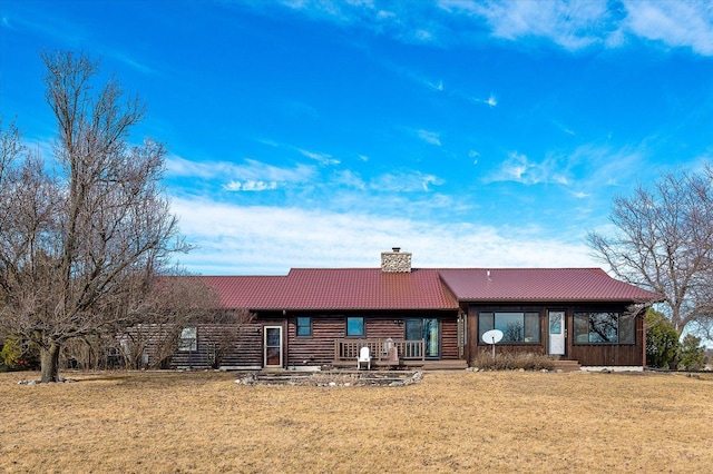 view of front of house featuring a chimney, a front yard, and a tile roof