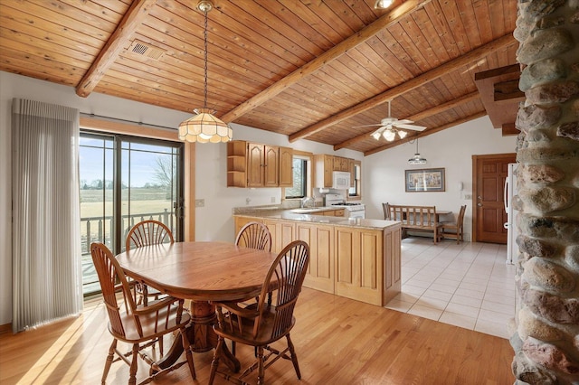 dining area with vaulted ceiling with beams, light wood-type flooring, wood ceiling, and a healthy amount of sunlight