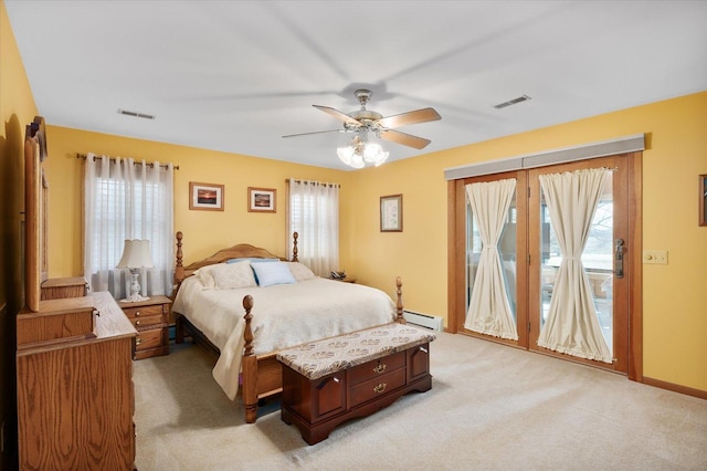 bedroom featuring multiple windows, access to outside, baseboard heating, and visible vents