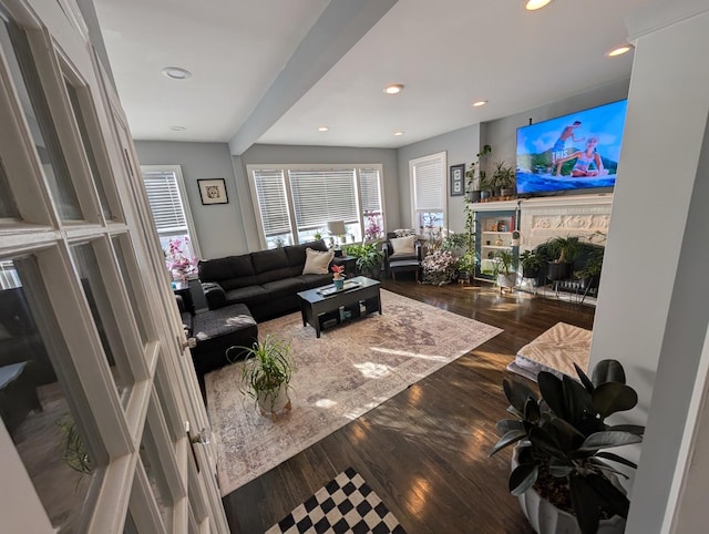 living room featuring recessed lighting, dark wood-style flooring, and a fireplace