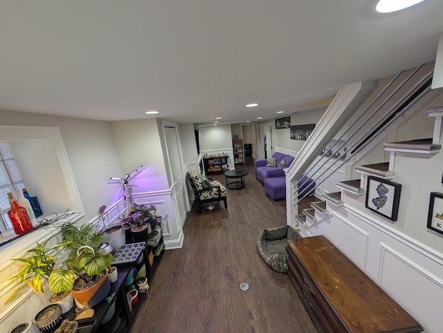 living area with recessed lighting, wood finished floors, and stairs