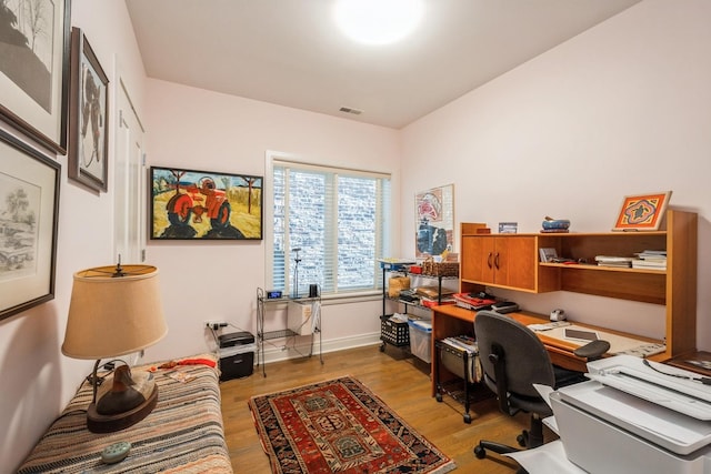 home office featuring baseboards, visible vents, and light wood-style floors