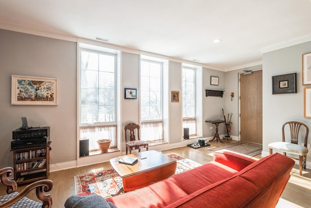 living room featuring recessed lighting, visible vents, light wood-style floors, ornamental molding, and baseboards